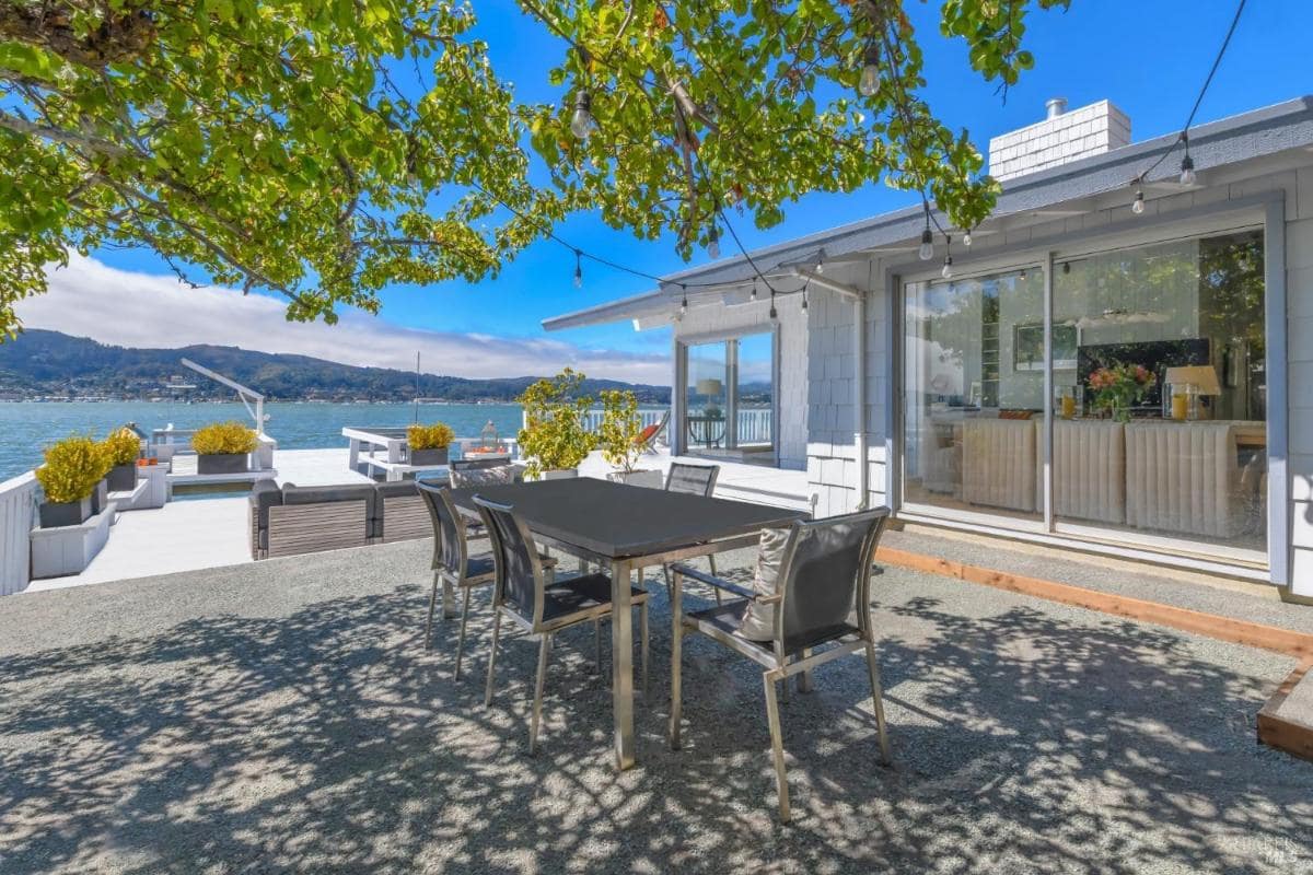 Patio area with dining table and view of the waterfront.