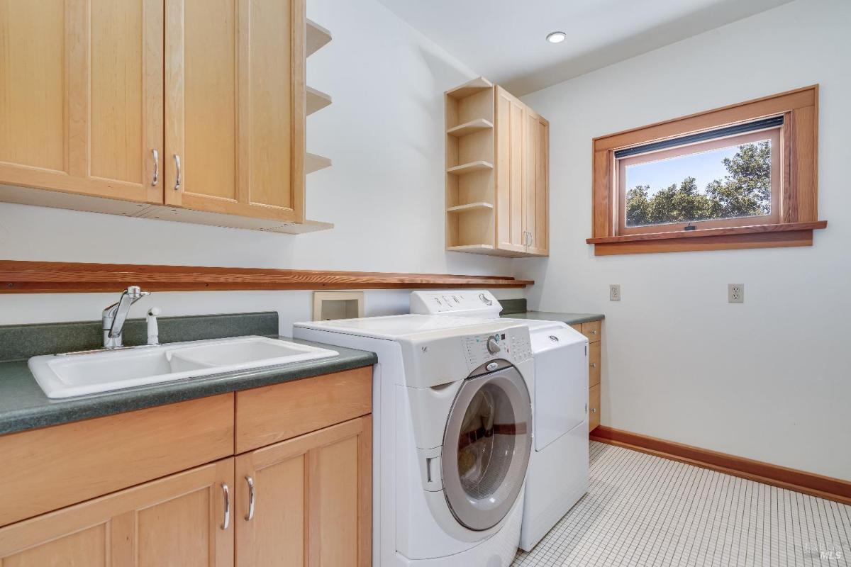 Laundry room with a washer, dryer, and built-in cabinets.