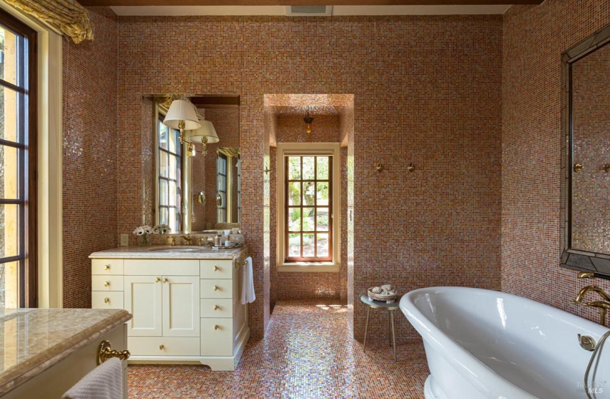 Bathroom with tiled walls and freestanding tub.