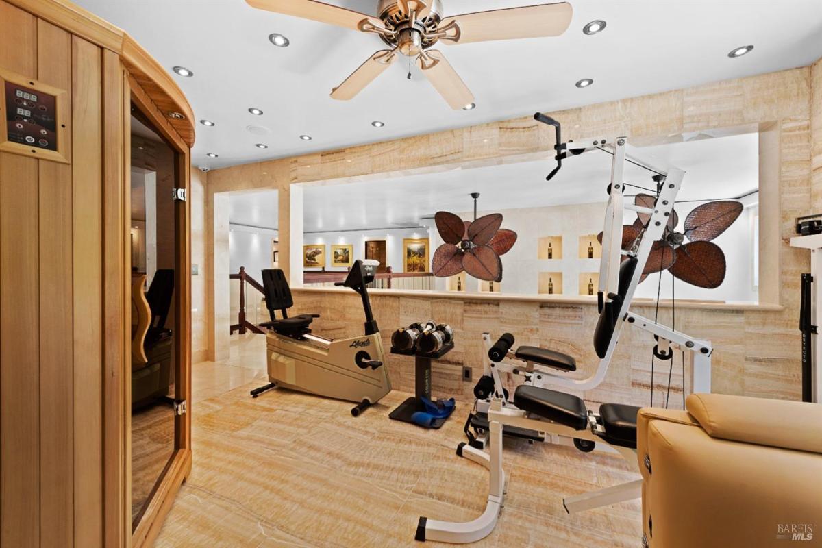 A home gym with various exercise equipment, including a sauna, weight bench, and multi-gym machine.