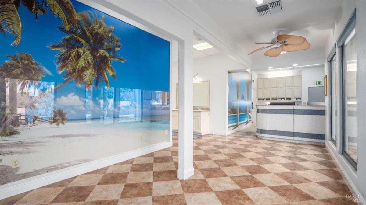 Room with beach-themed mural and tile flooring.