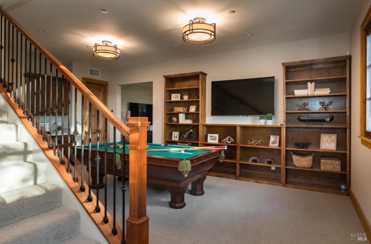 Recreation room with pool table and staircase.