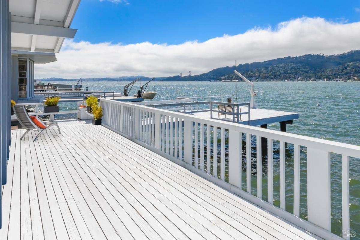 Waterfront deck with lounge chairs and panoramic water view.