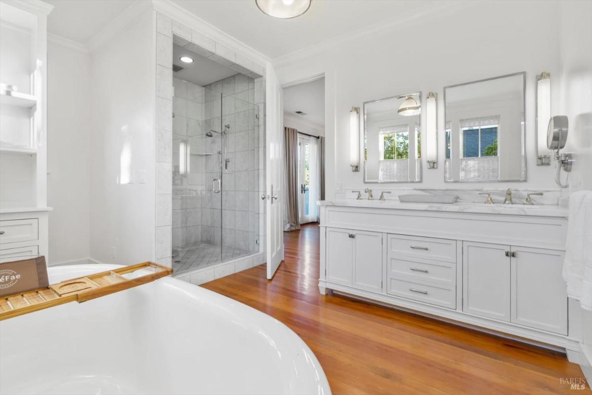 A bathroom with a soaking tub, double vanity, and a glass shower.