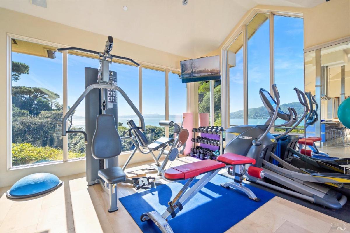 This gym offers exercise equipment and expansive views through floor-to-ceiling windows overlooking the water.