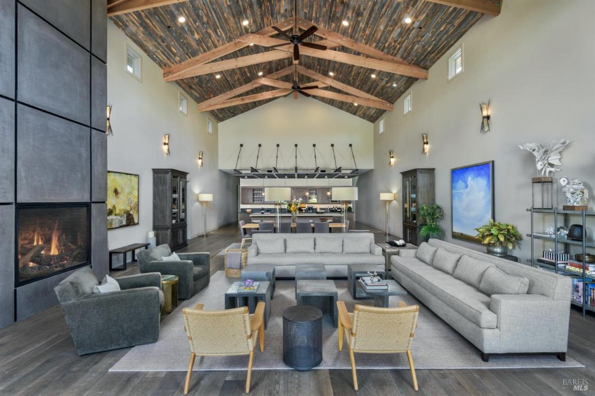 Spacious living room with high ceilings, a fireplace, and seating arrangements.