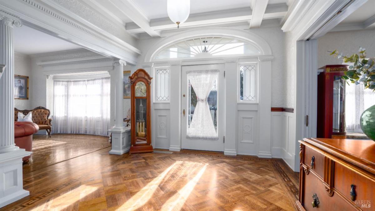 Entryway with glass-paneled doors and decorative molding.