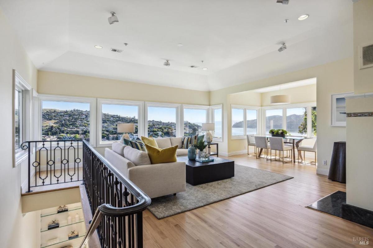 Living area with large windows offering hillside and water views.