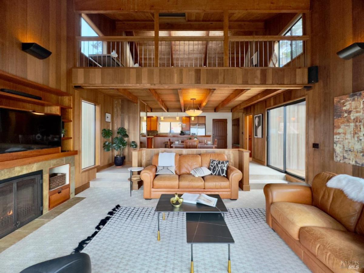 Living room with leather couches and wooden panel walls.