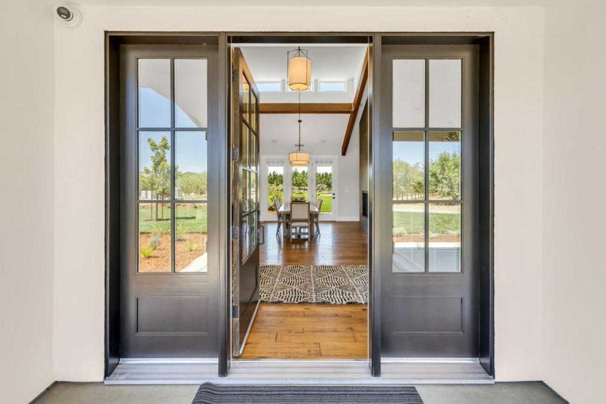 A front entrance with double doors opening to a view of the dining area.