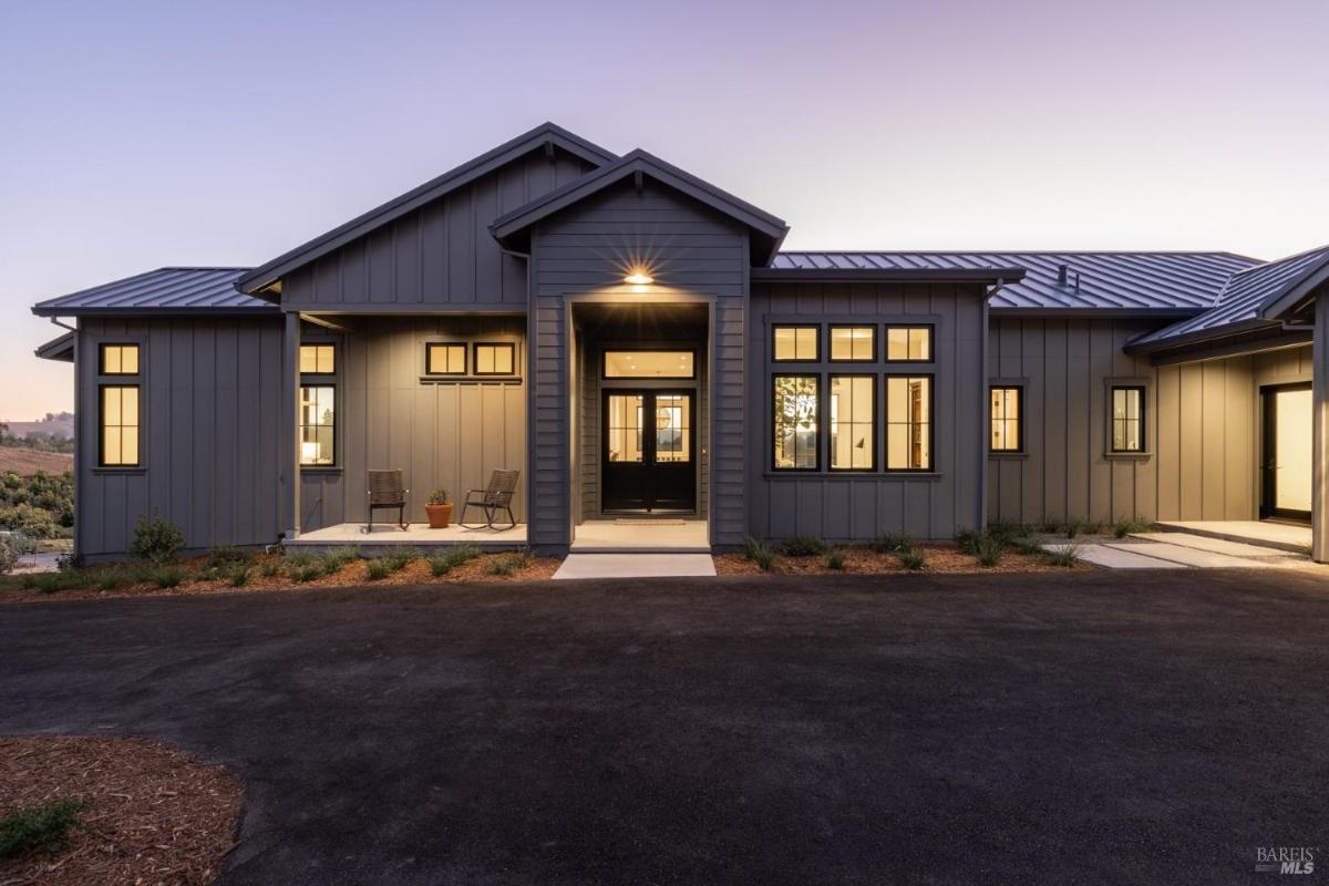 A modern house with a symmetrical design and a pathway leading to the entrance.