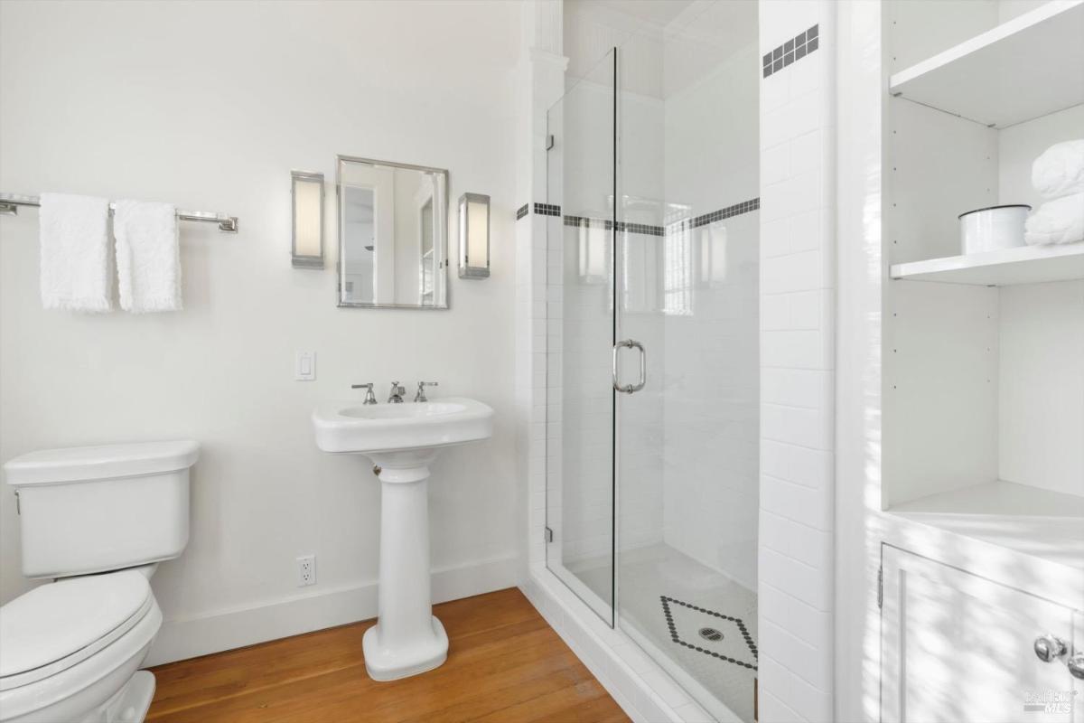 Shower enclosure with glass doors and white tile walls