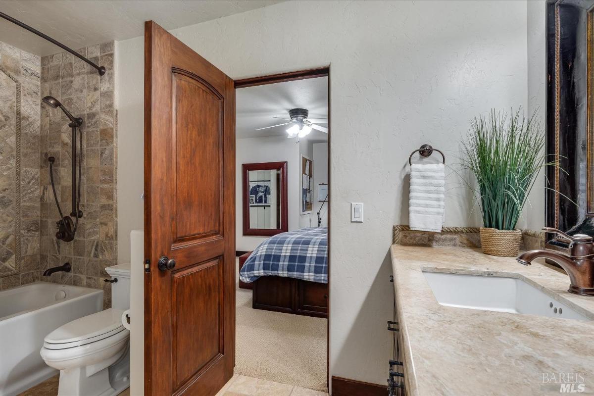 A bathroom with stone walls, a bathtub, and a sink vanity.