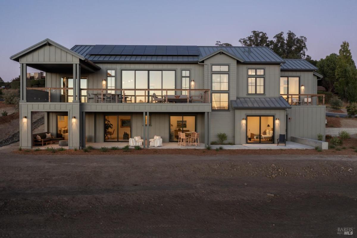 A modern house with a symmetrical design and a pathway leading to the entrance.