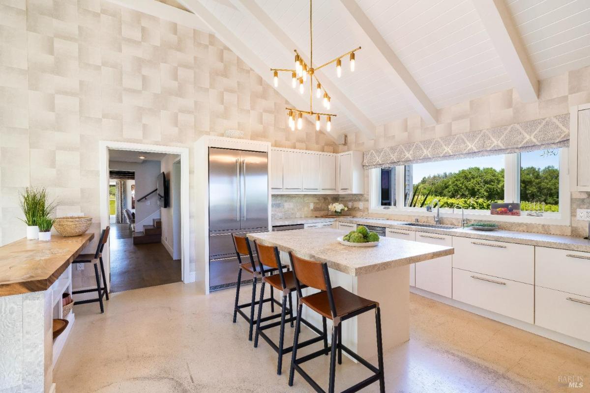 Wide view of the kitchen with high ceilings and a large island.