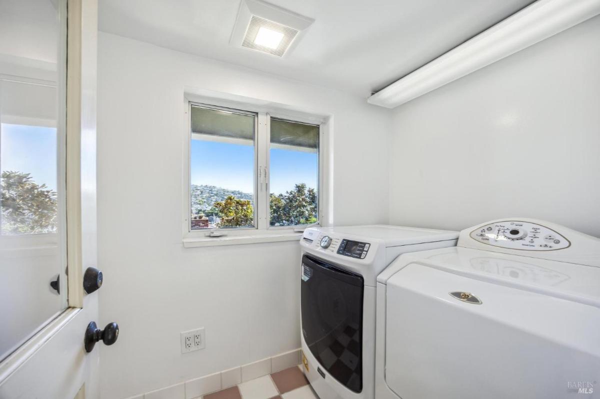 Laundry room with washer, dryer, and a window with views.