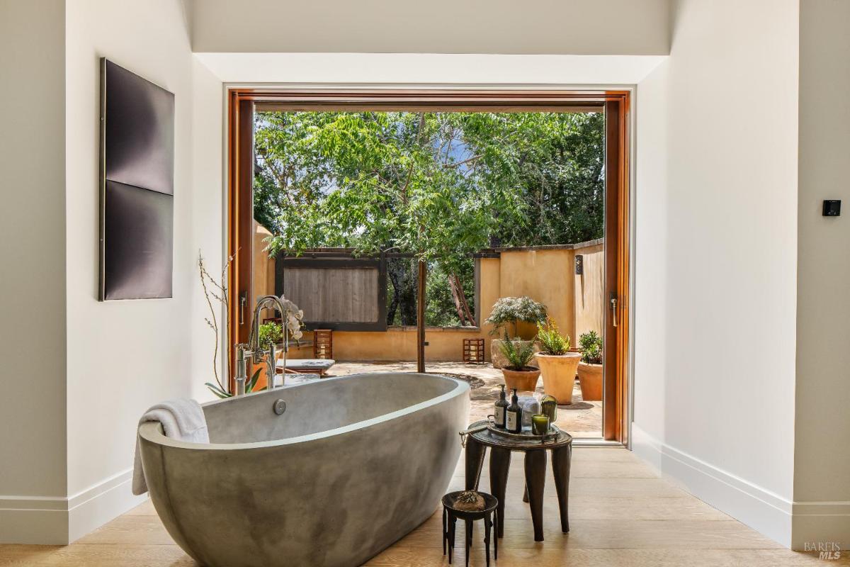 Bathroom with a freestanding bathtub and sliding doors leading to an outdoor patio.