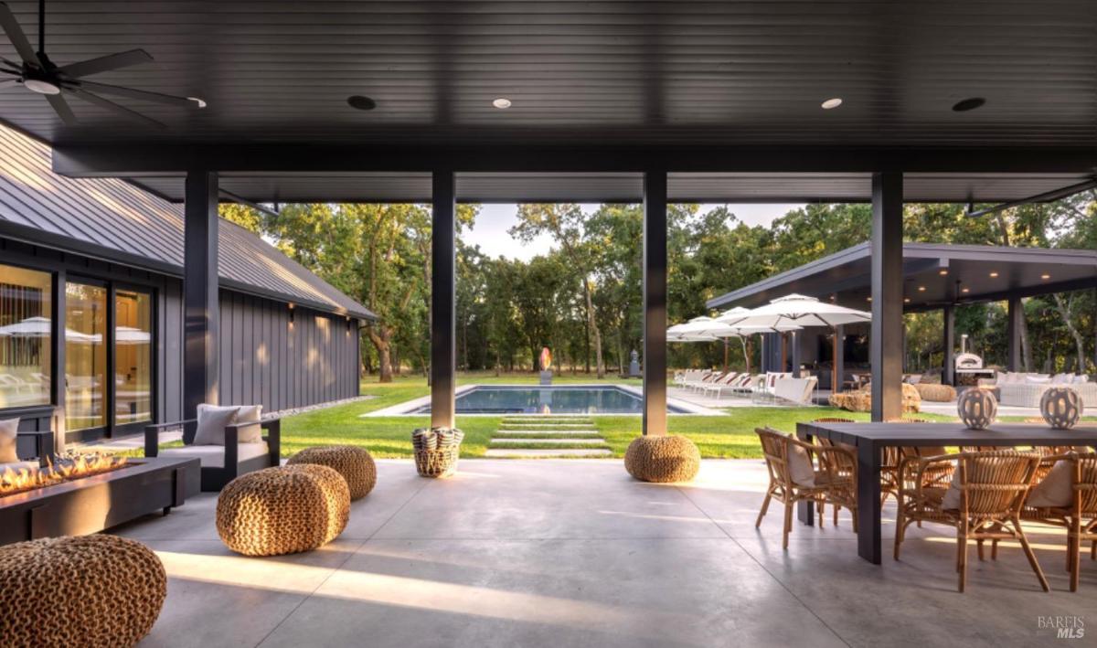 A terrace with fire pits, outdoor seating, and a view of the pool and surrounding lounge area.