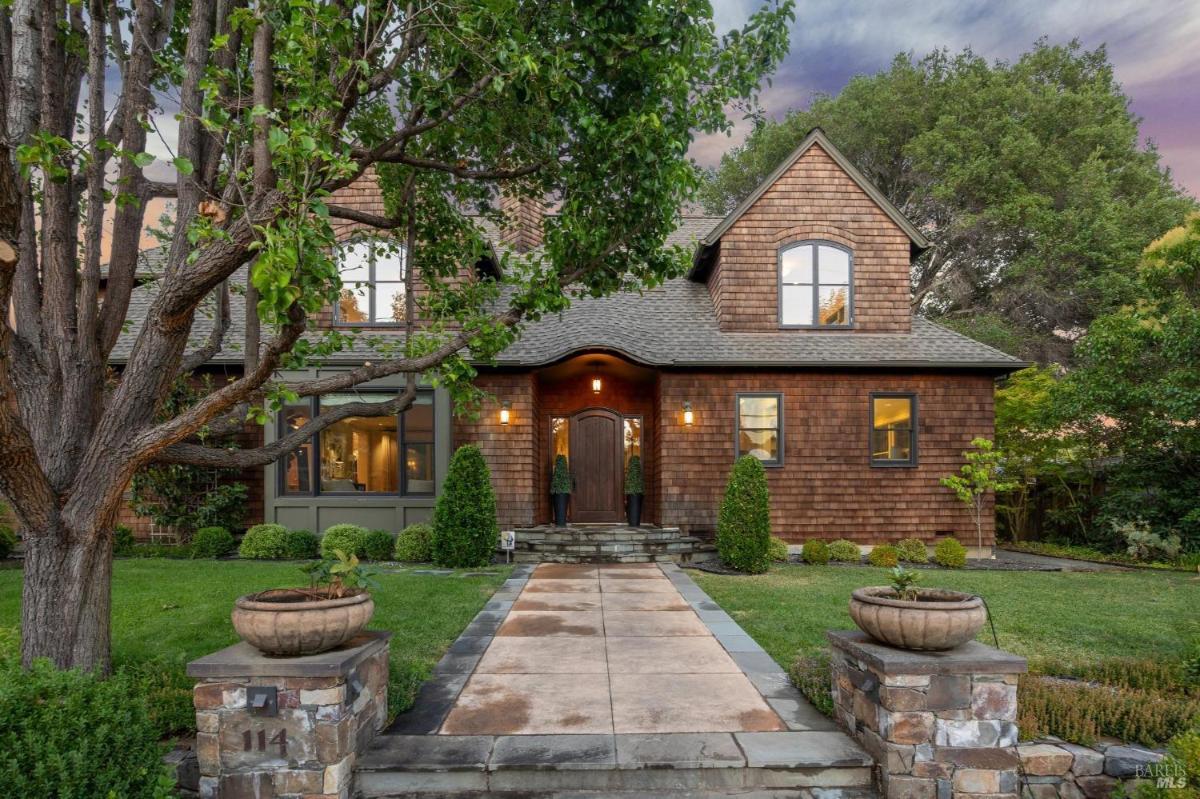 Front exterior of a two-story house with a wooden facade and stone accents.