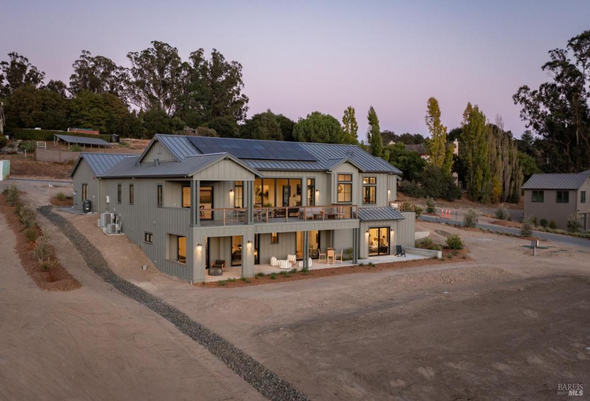 A modern house with a symmetrical design and a pathway leading to the entrance.