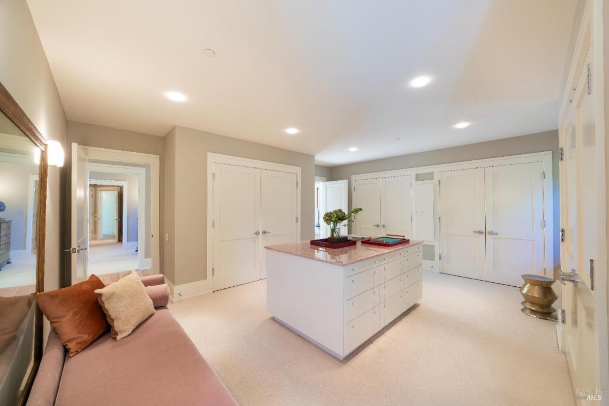 A spacious closet with built-in cabinets and a center island.