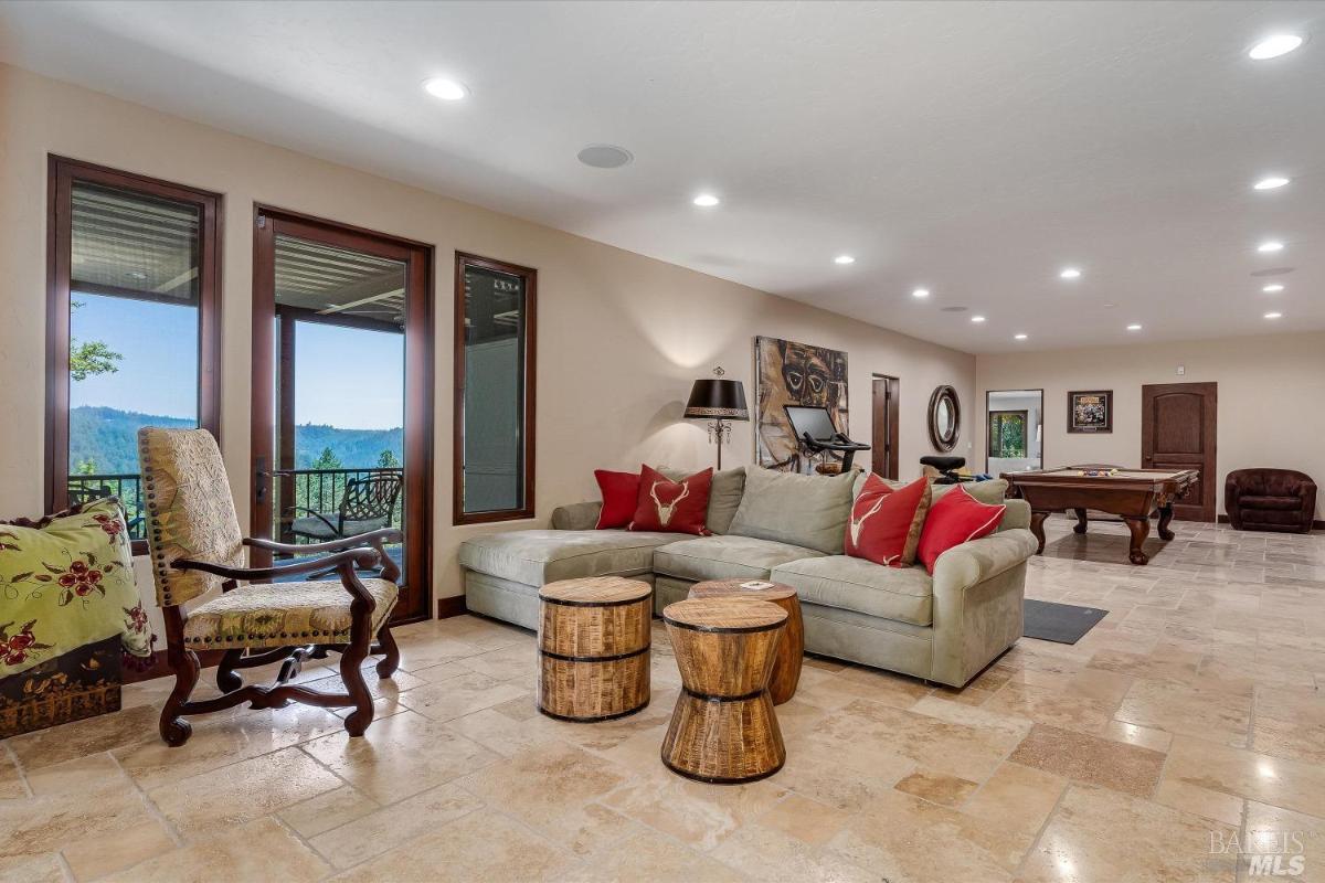 A game and recreation room with a sectional sofa, pool table, and wall art.