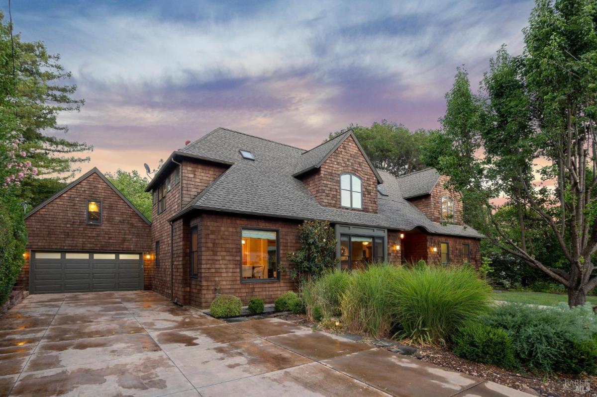 Driveway and side view of a two-story house with a garage.