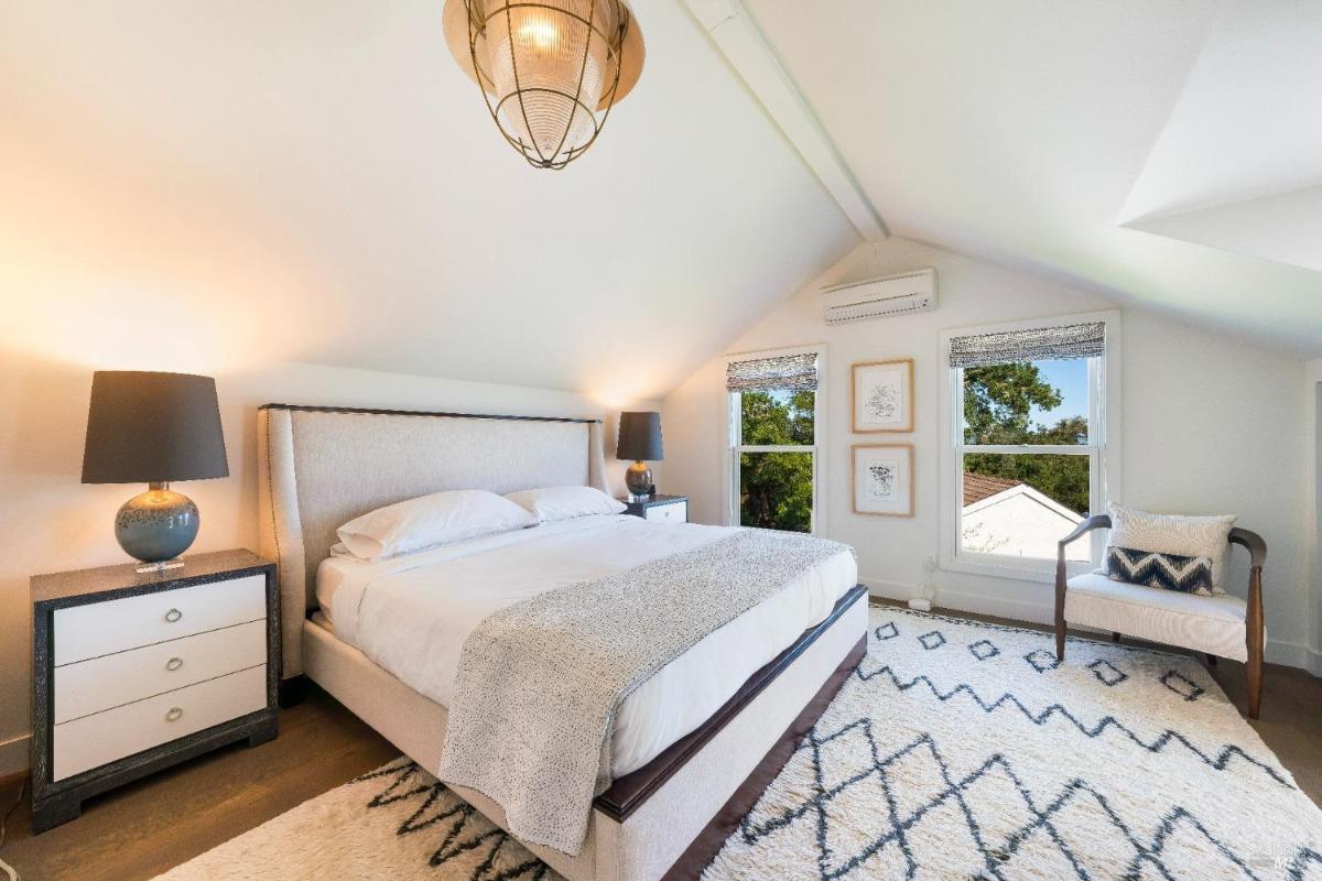 Bedroom with a simple bed, nightstands, and angled ceiling.