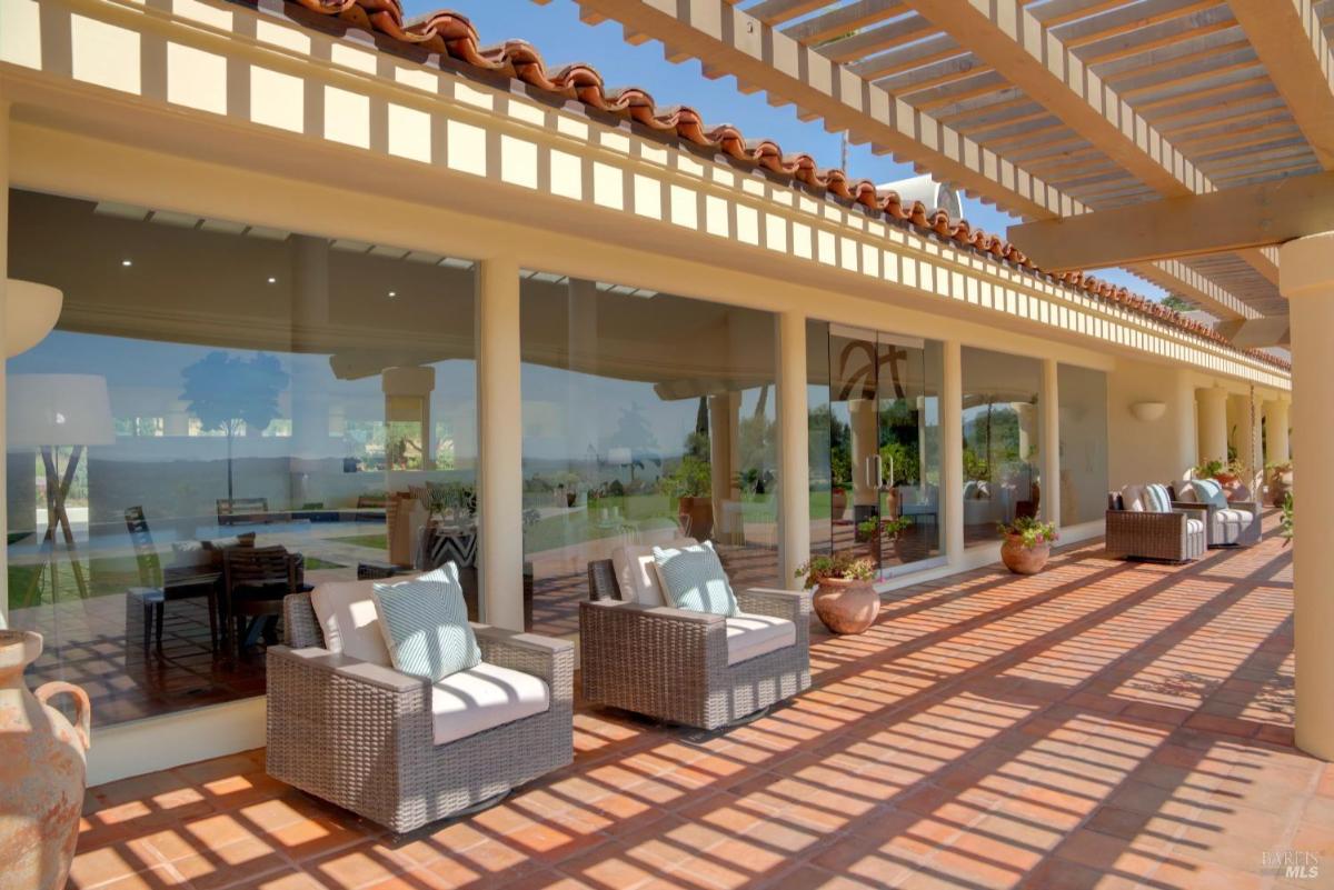 A patio with chairs and a shaded seating area.