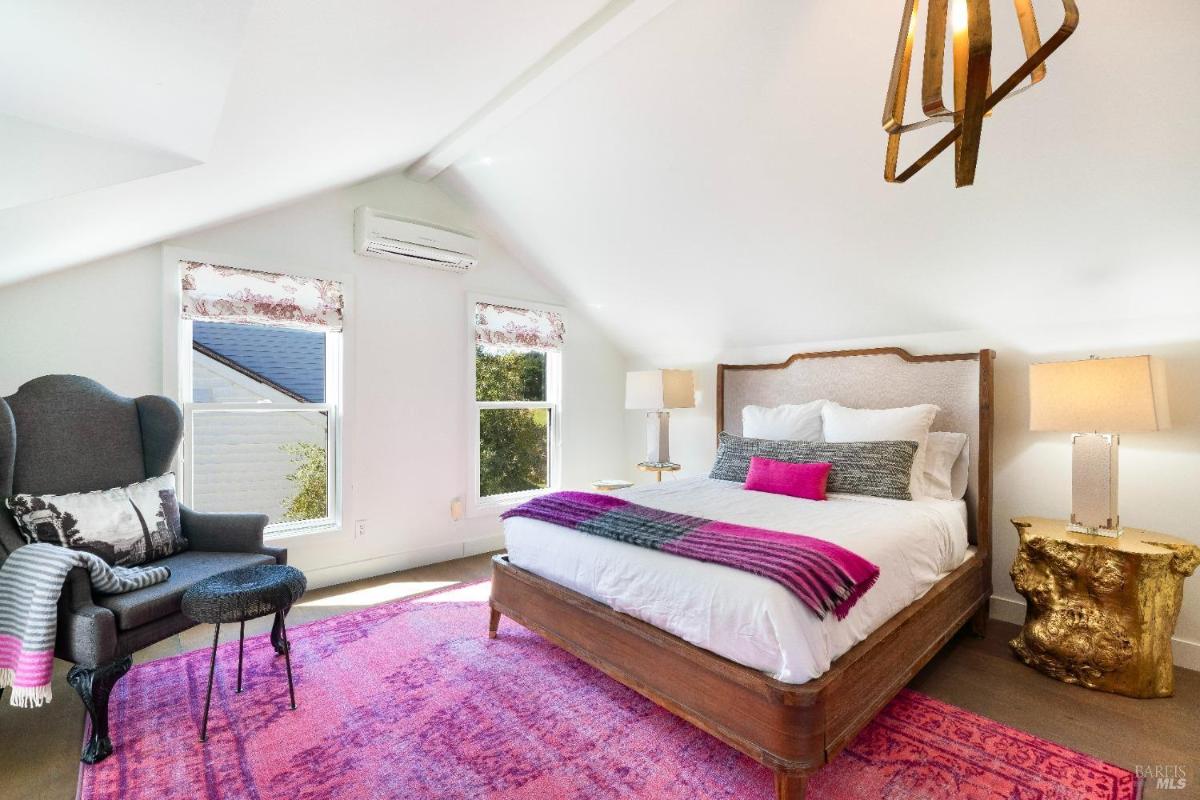 Bright bedroom with a colorful rug and wood accents.