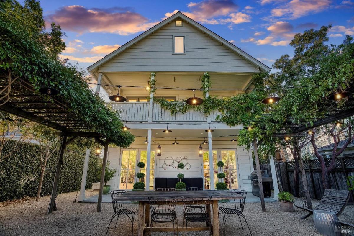 Two-story exterior view with outdoor seating area and hanging lights