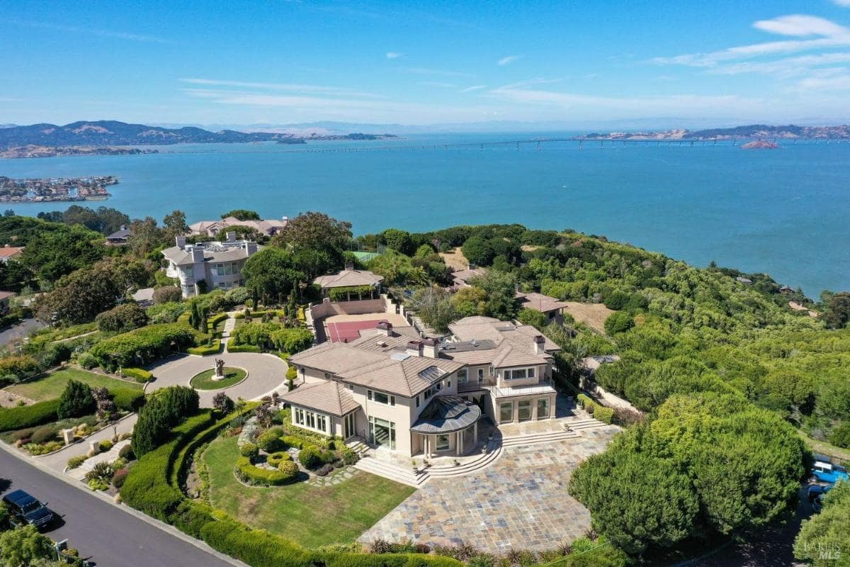 Aerial view of the mansion with the surrounding landscape and bay.