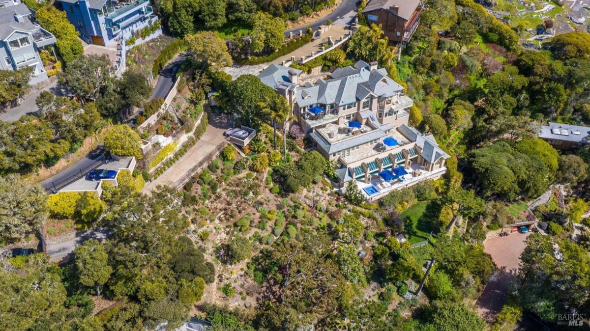 A detailed aerial view of the estate, featuring multiple terraces, landscaped gardens, and the indoor pool area.