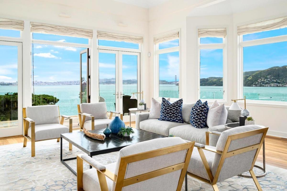 Living room with a sofa set, chairs, and large glass doors leading outside.