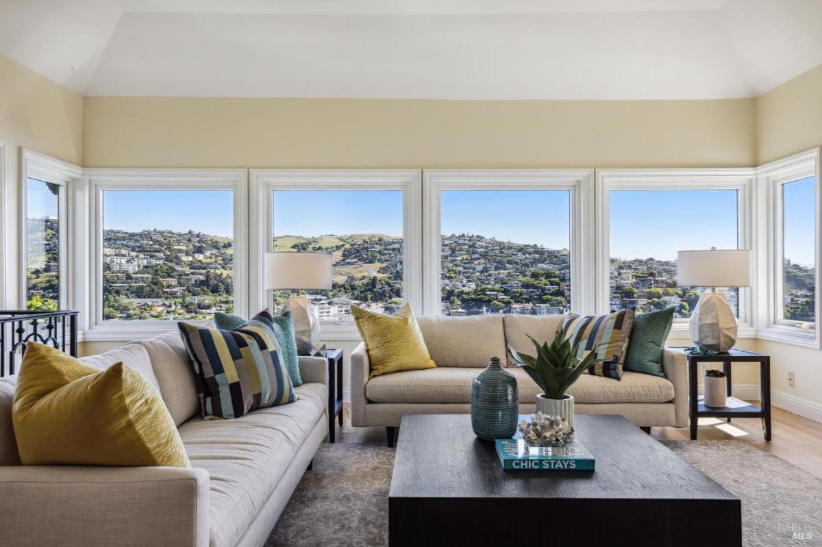 Living area with large windows offering hillside and water views.