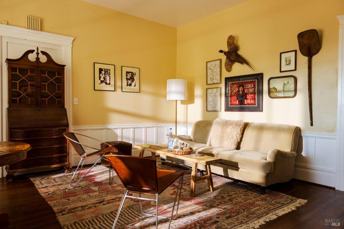 A sitting room with a sofa, chairs, and wall decor.