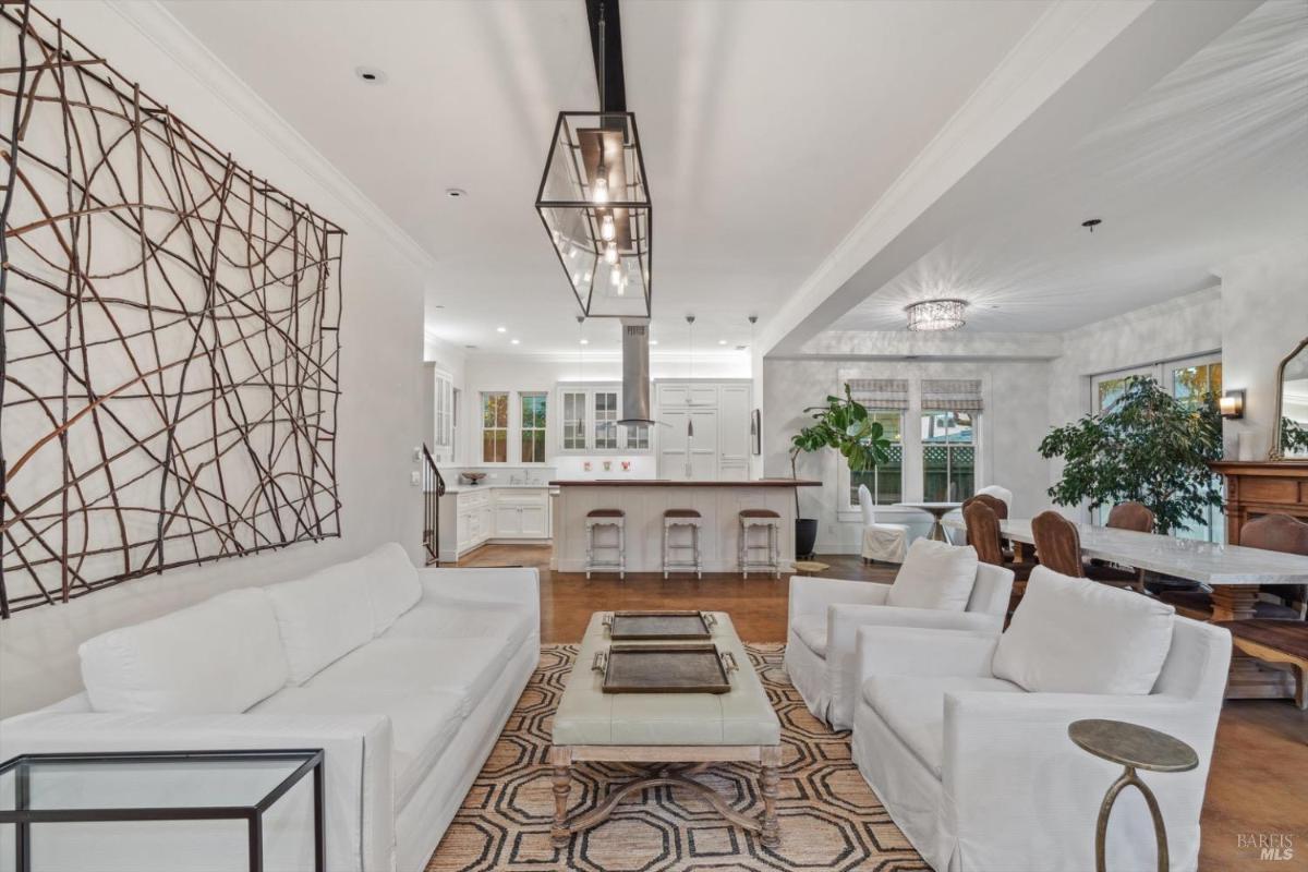 Living room with white furniture, a TV, and a geometric-patterned rug.