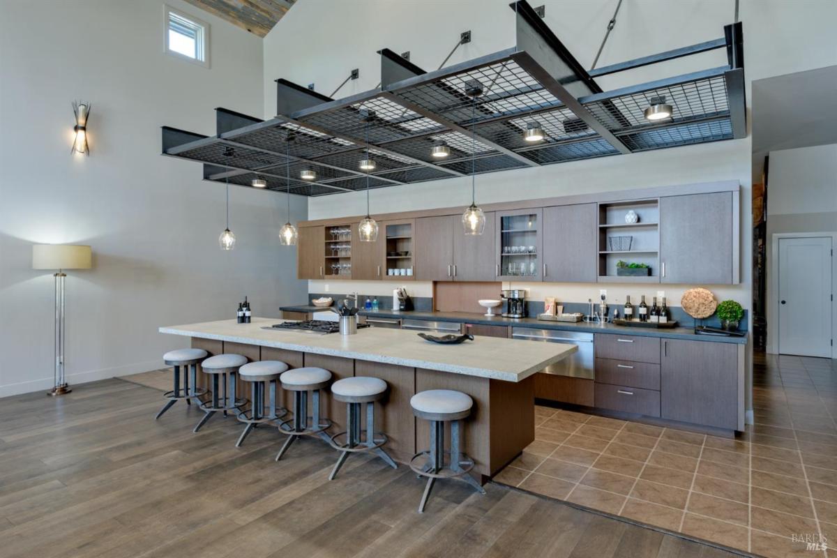 Modern kitchen with a large island, pendant lighting, and cabinets.