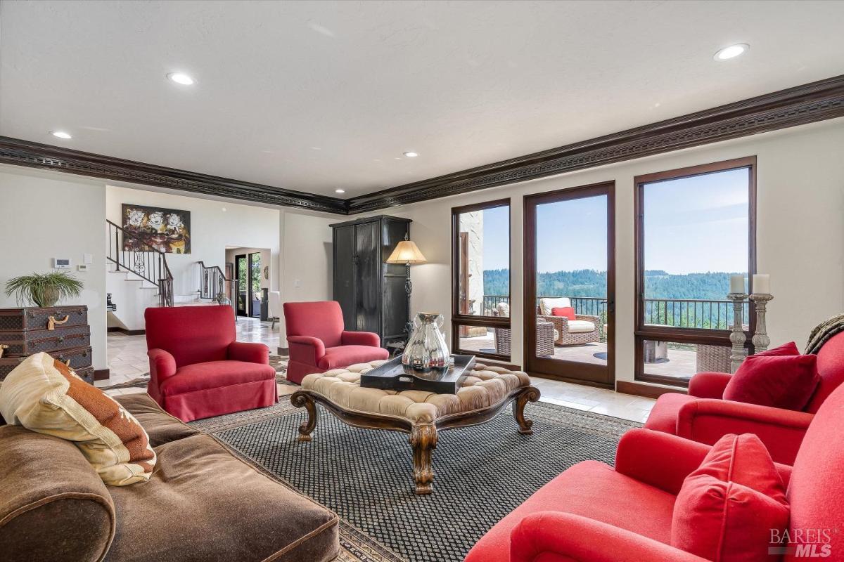 Living room with seating, ottoman, and panoramic outdoor views.