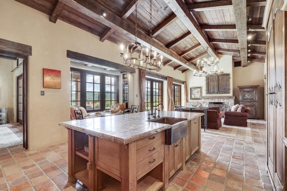 Open kitchen and dining area with exposed wooden beams.