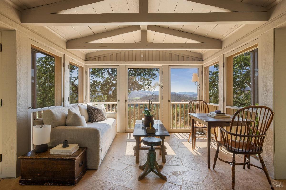 Enclosed sitting area with multiple windows and outdoor views.