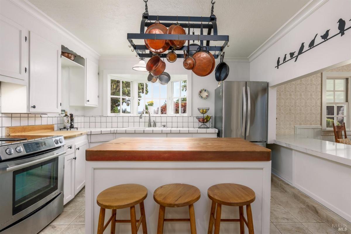  Kitchen island with hanging pots and stools.