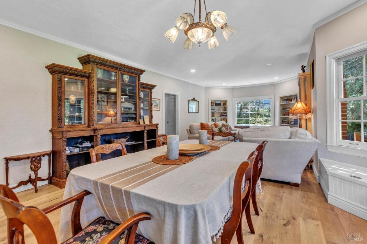 A dining room with a large wooden table, chairs, and a built-in cabinet.