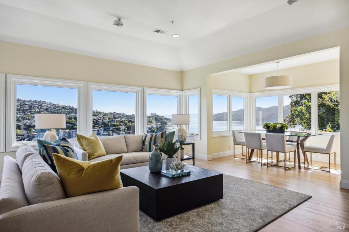 Close-up of a seating arrangement in a living room with hillside views through windows.