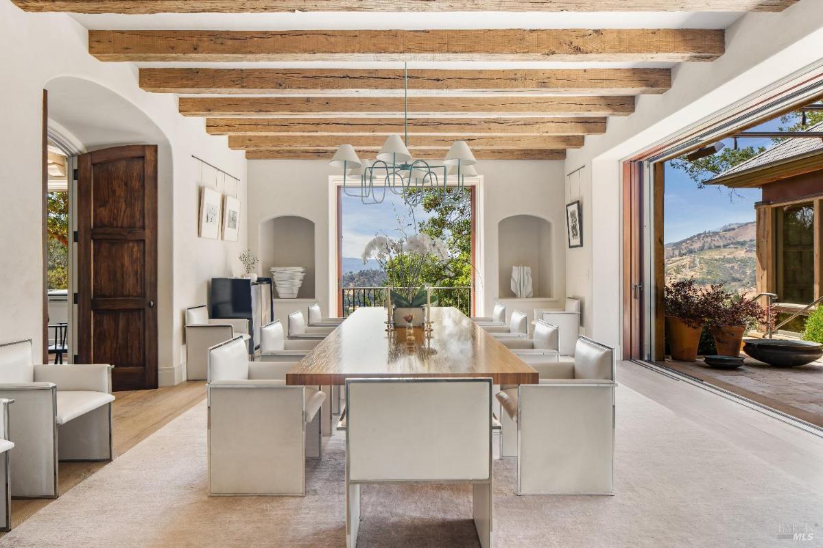 Dining room with exposed wooden beams and seating for twelve.