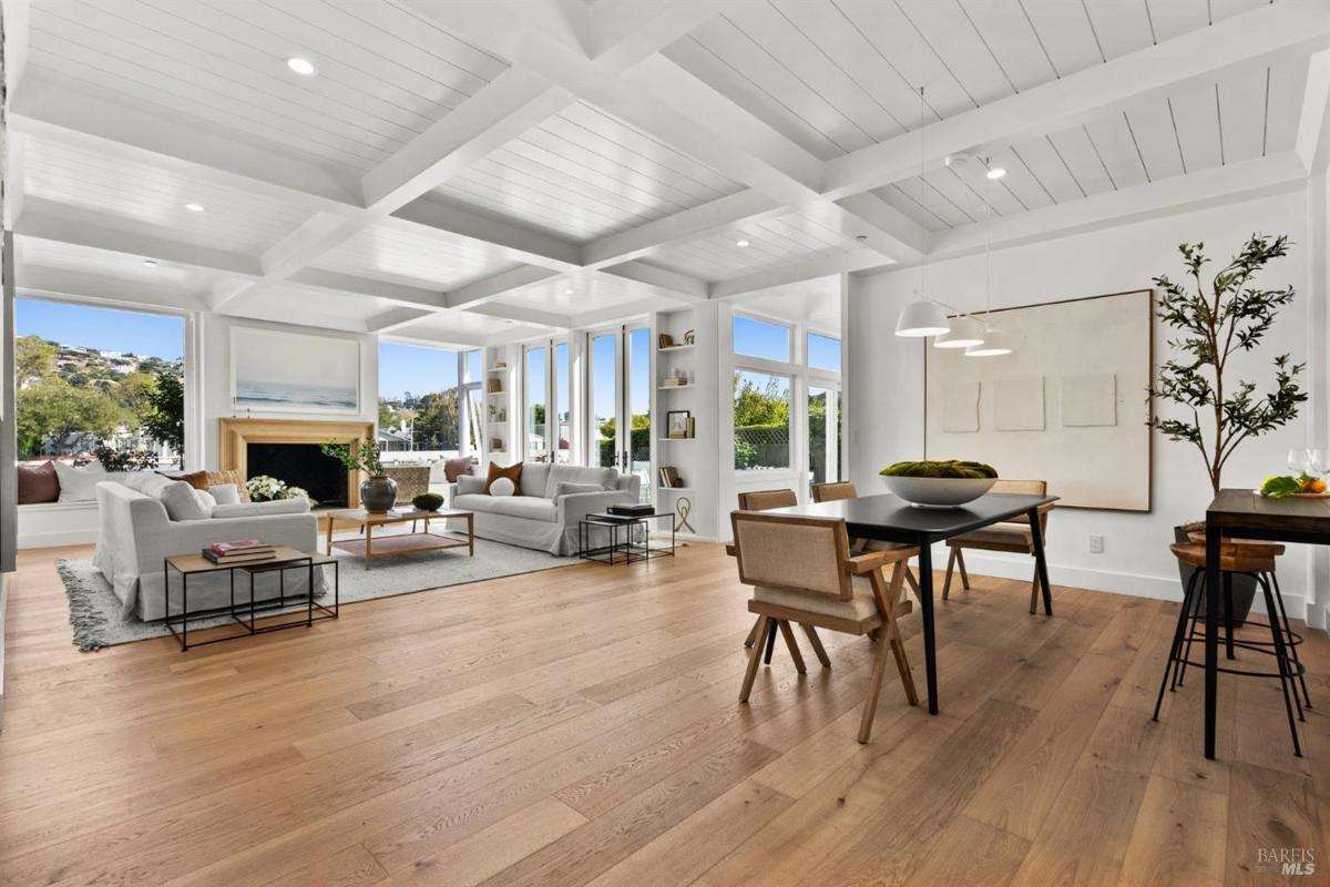 An open-plan space with a living area, dining area, and wood flooring.