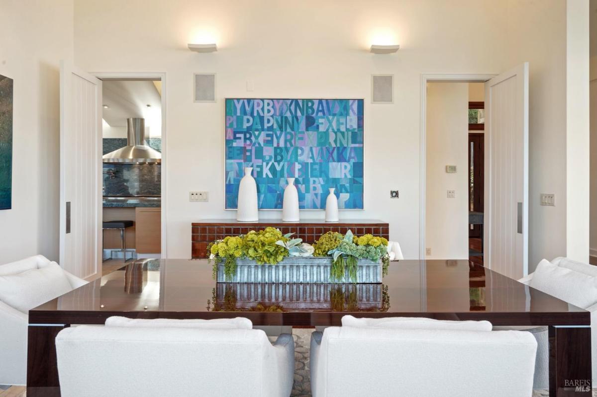 Close-up of a dining table with centerpiece, flanked by chairs.