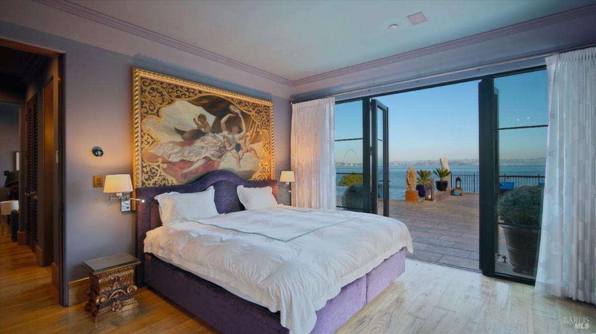 Bedroom with a mural, glass doors, and outdoor terrace.