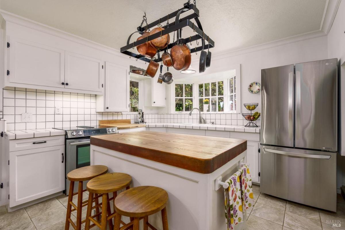 Kitchen showing white cabinets, a refrigerator, and a stove.