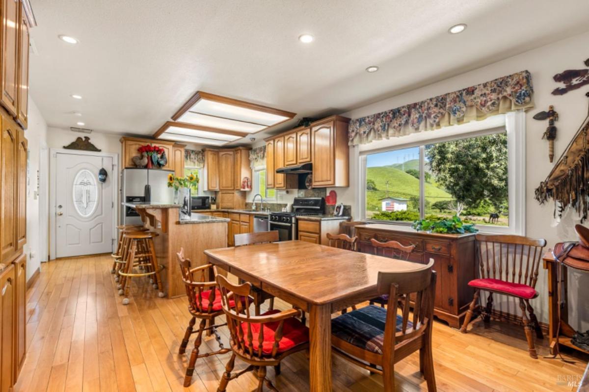 Open kitchen and dining area with wooden cabinets and granite counters.